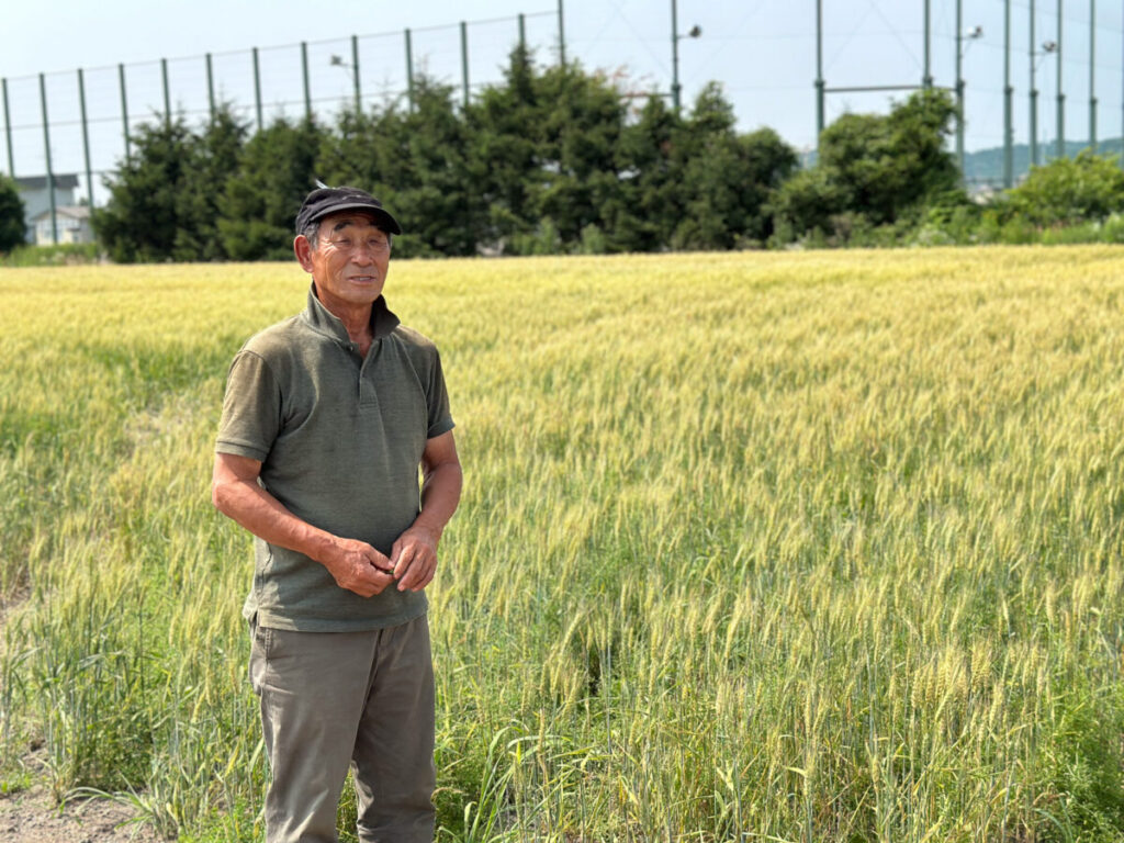 麦畑の前の今村さん